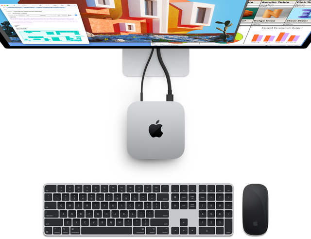 Mac mini i sølv vist ovenfra, med Apple-logo, vist koblet til en skjerm og ved siden av et trådløst Magic Keyboard og Magic Mouse